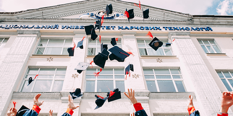 graduation hats being thrown in air