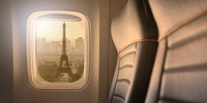 Picture of airplane window with the Eiffel tower